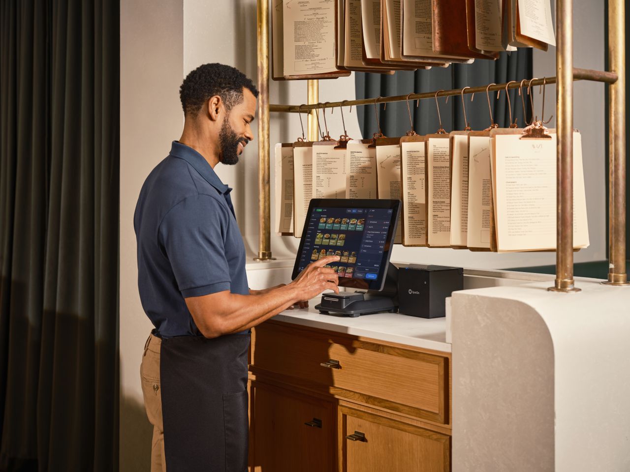 About A restaurant server operates a touchscreen POS system, enhancing efficient order management.